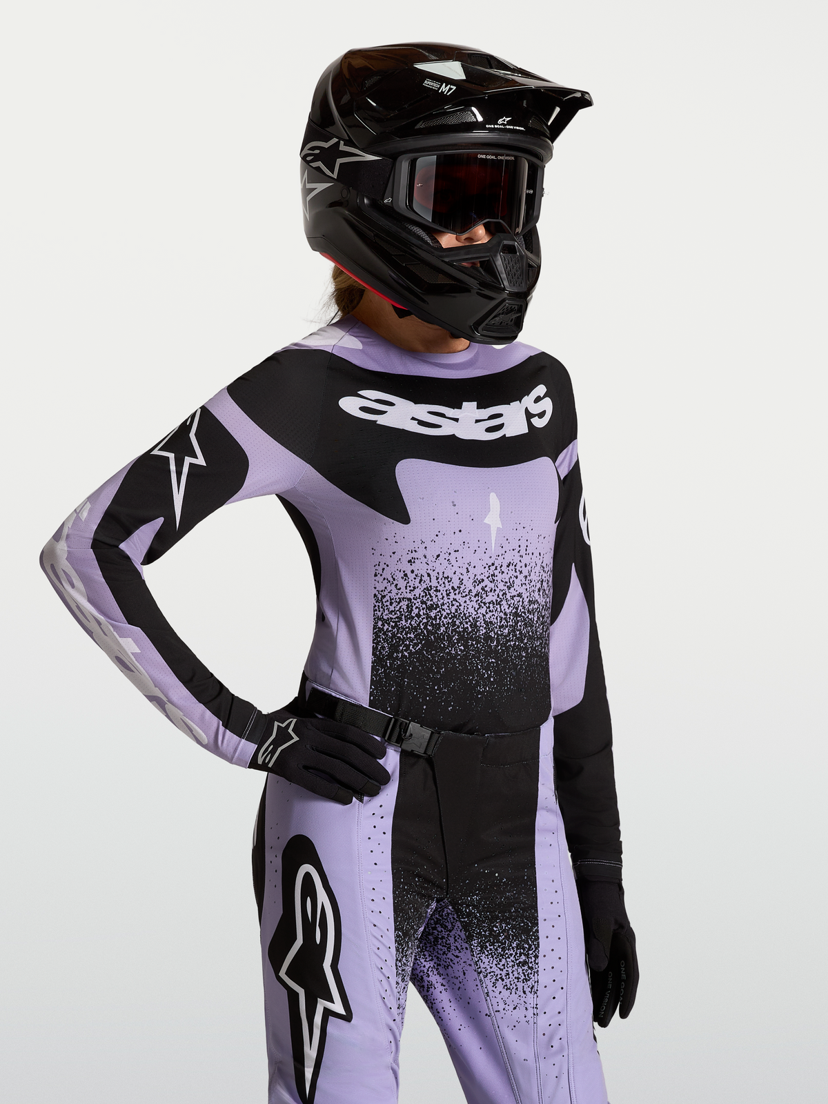 Stella Techstar Swan tröja, motocrosströja för dam i ljuslila och svart, atletisk racingpassform med laserperforerad ventilation, visas på modell med matchande hjälm och utrustning för terrängkörning
