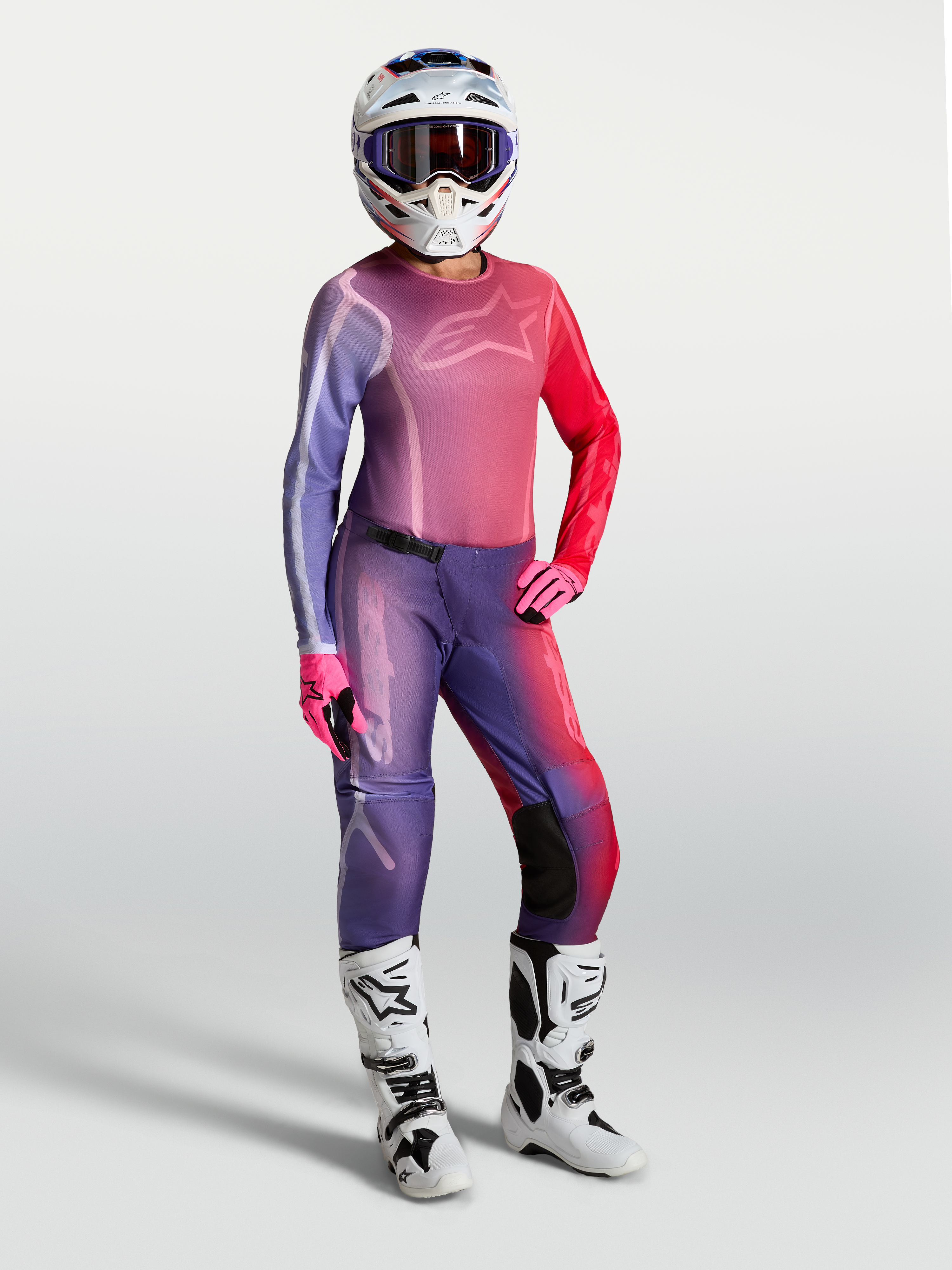Alpinestars Stella Fluid Kepler utrustningsset, motocrossutrustning för damer i lila och röd gradient, matchande tröja och byxor med vita stövlar och hjälm för terrängkörning.