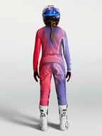 Alpinestars Stella Fluid Kepler tröja, motocrossutrustning för dam, lila och röd, fukttransporterande polytyg, sedd bakifrån på modell med matchande byxor och hjälm.