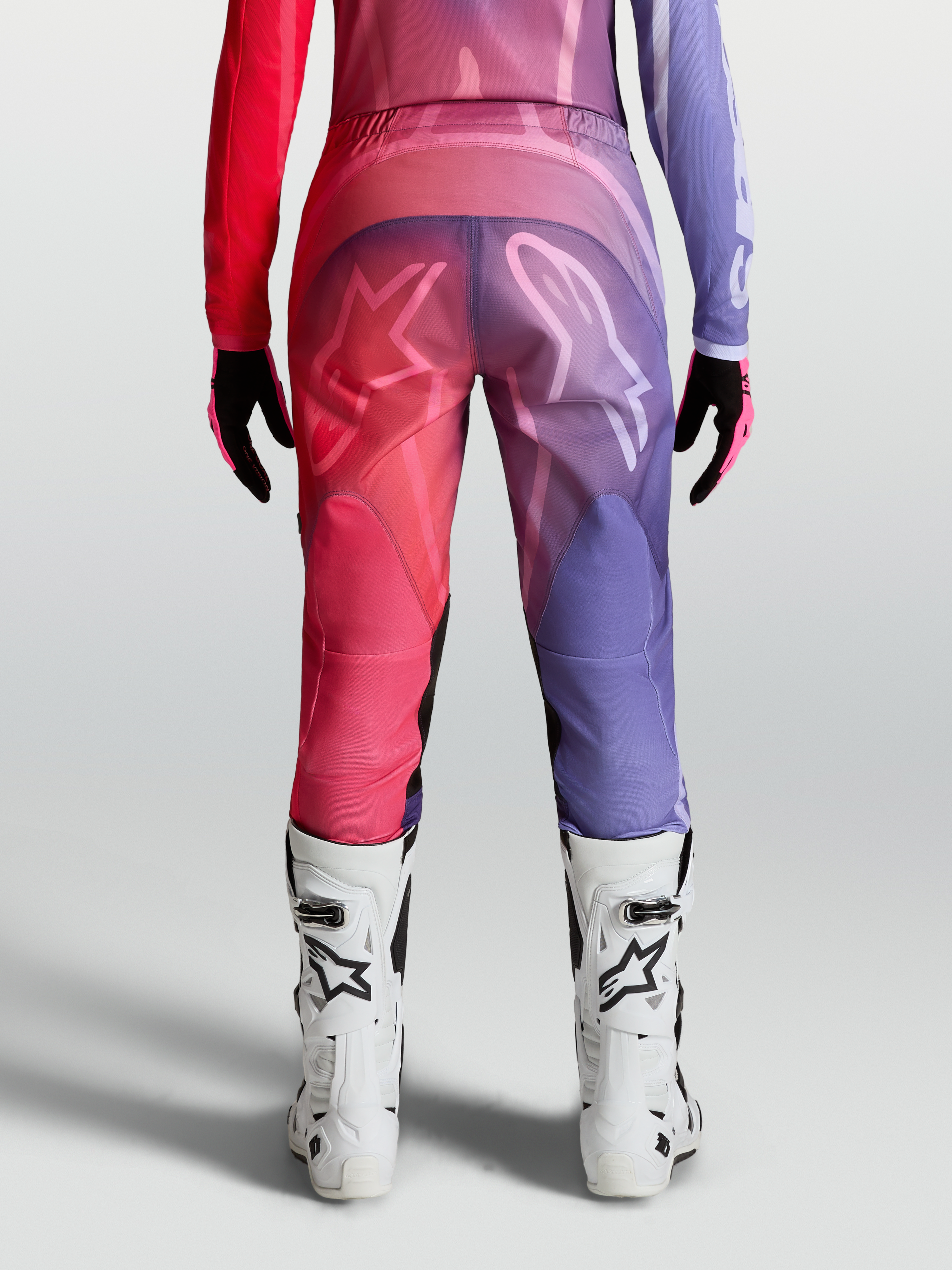 Alpinestars Stella Fluid Kepler byxor, dam-motocrossbyxor, lila och röda, vy bakifrån med förböjda ben och ergonomisk passform