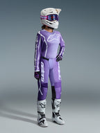 Alpinestars 2026 Stella Fluid Apex Gear Set, Purple and Lavender, Female motocross rider wearing matching jersey and pants, white helmet with purple goggles, white and black boots, black and purple gloves, complete performance outfit for women's off-road racing
