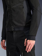 Alpinestars Troop-Air Pro-jacka i Black Black, närbild av teknisk bepansrad ventilerad jacka med detaljerad 2D-tech-mesh-konstruktion, fickor med dragkedja och elastisk fåll med Alpinestars-branding, ärmar med integrerade tumöglor, kombinerad med matchande motorcykelutrustning.