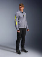 Alpinestars Chrome V2 Sport Hoodie, gråmelerad och fluogul, bärs av en manlig modell med svarta byxor och svarta mc-skor, med framträdande gul logotyp på ärmen och bröstet, avslappnad urban motorcykelutrustning