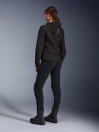 Alpinestars Stella Radium Tech Hoodie, svart urban motorcykelhuvtröja för dam, vy bakifrån som visar 'ALPIN'-logotyp på huvan, matchad med svarta tekniska körbyxor och svarta stövlar, lätt vindtätt tekniskt skal.