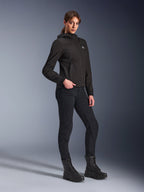 Alpinestars Stella Radium Tech Hoodie, svart urban motorcykelhoodie för damer, bärs med svarta körbyxor och kängor i taktisk stil, smal atletisk passform, vindtätt tekniskt skal i tre lager, minimalistisk design med liten logotyp på bröstet, helkroppsbild i studiomiljö