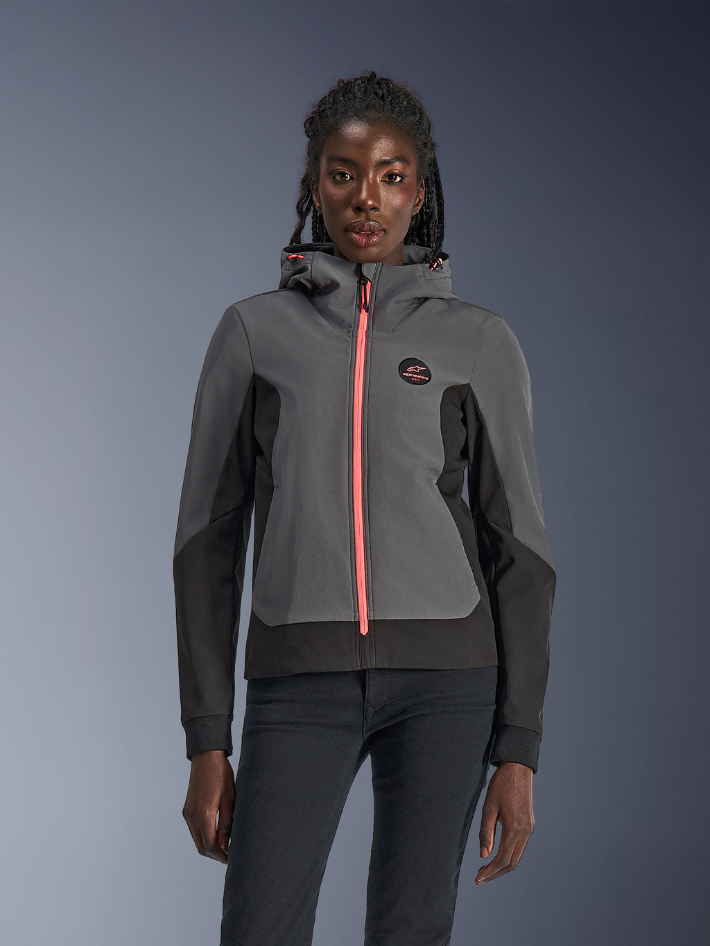 Alpinestars Stella Radium Tech Hoodie, motorcykelhoodie för dam, mörkgrå och svart med stark rosa dragkedja och dragskor till huvan, buren av en modell, sportig urban design med Alpinestars logotyp på bröstet