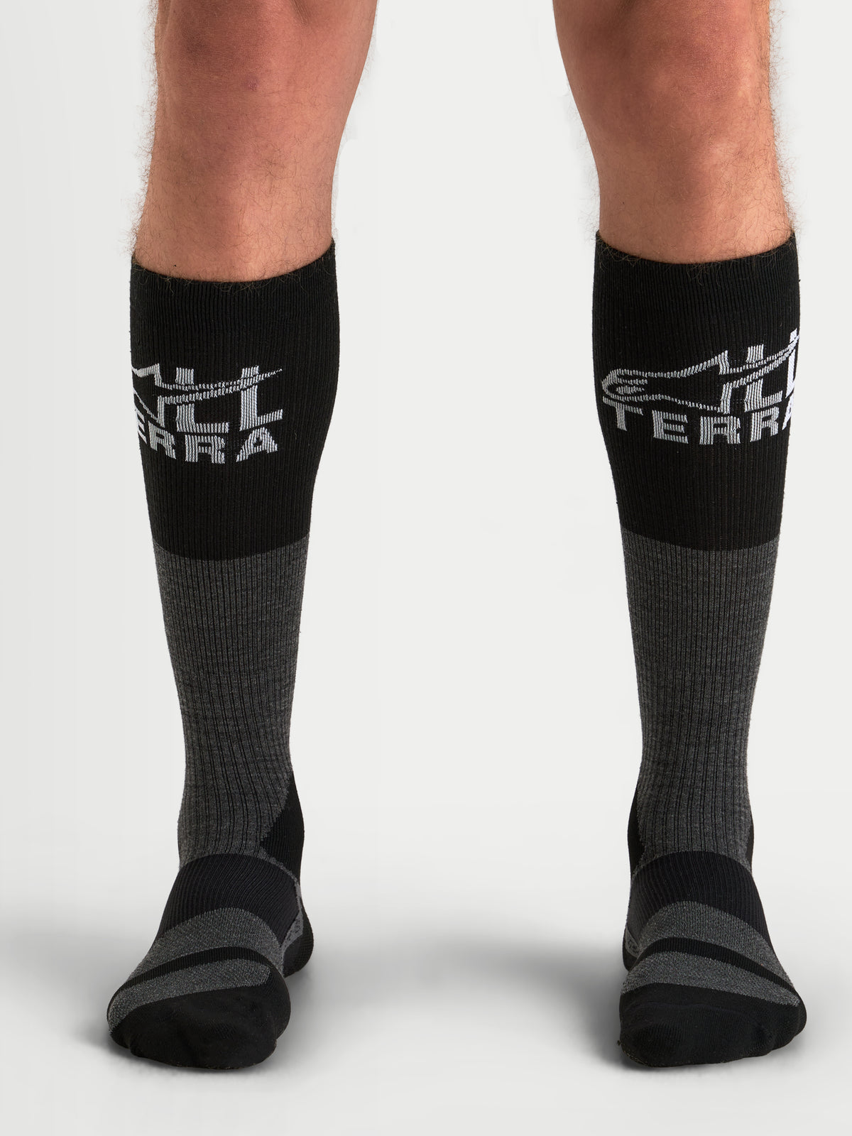 Alpinestars AT-8 Merino strumpor, äventyrsmotorcykelstrumpor för herr i mörkgrått och svart, termiska merinoblandade funktionsstrumpor burna av modell som visar ribbad övre vad och förstärkta dämpningszoner