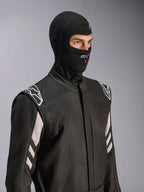 Alpinestars ZX Evo V3 Balaklava, svart, flamsäker huva för bilracing, bärs av en modell i en svart racingoverall med vita detaljer, har Alpinestars-logotyp på hakan, öppning för vätskeslang, professionell skyddsutrustning för motorsport