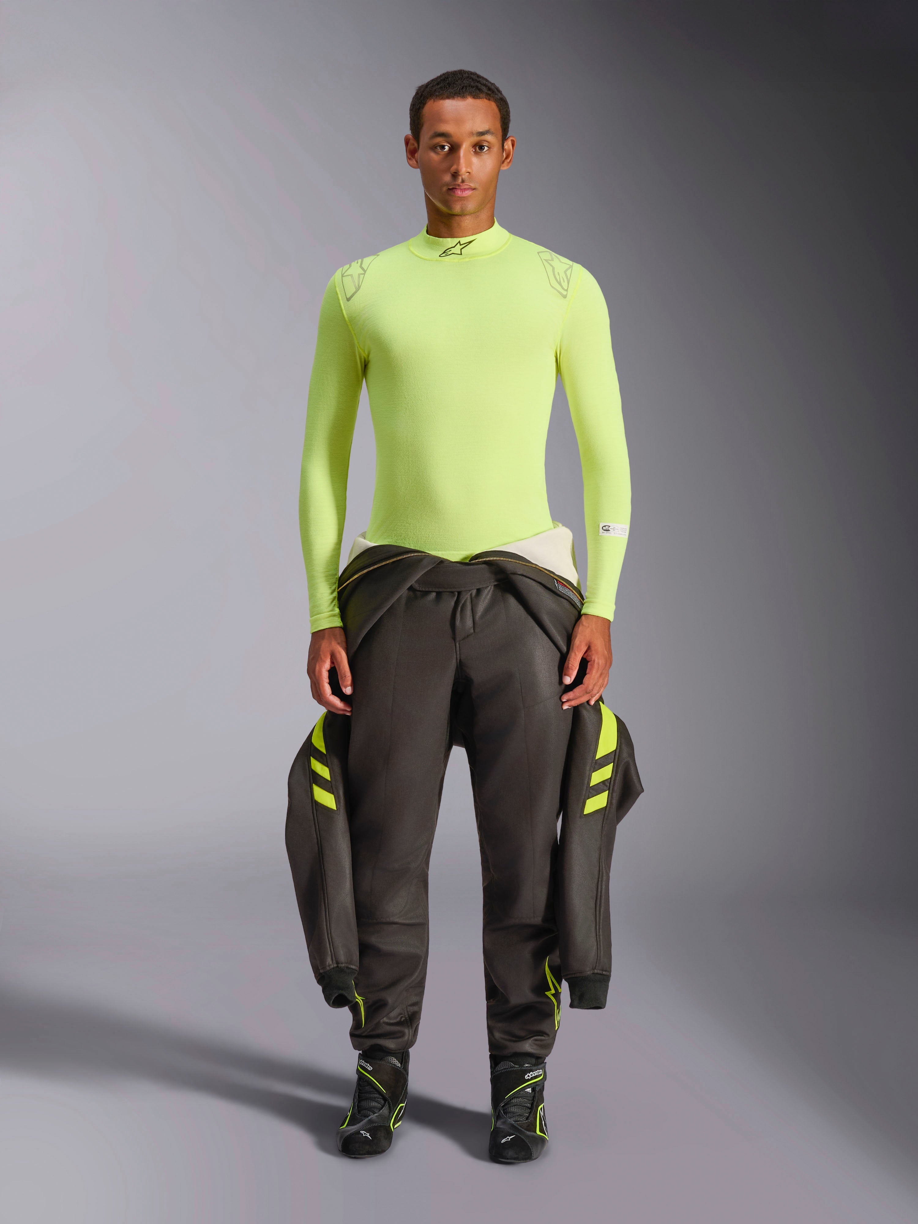 Alpinestars ZX Evo V3 Topp - Långärmad, Yellow Fluo, bärs av en modell med mörka racingbyxor och stövlar, med hög krage och atletisk passform, flamskyddat underställ för professionell racing