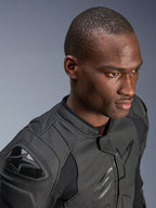 Närbild på en modell som bär Alpinestars Dusk Airflow läderjacka, Black on Black, med omfattande perforerat läder för andningsförmåga, externa DFS-axelskydd och en smidig, modern design för sportkörning.