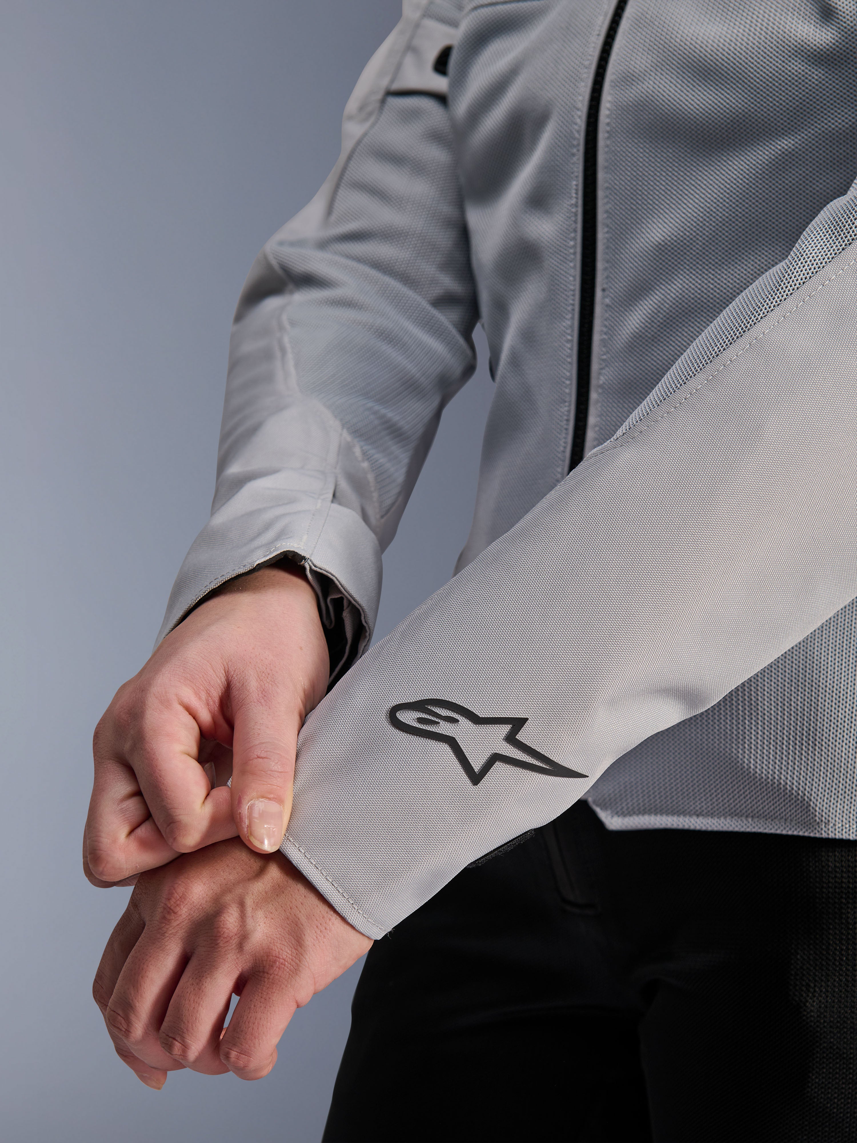 Close-up of Alpinestars Stella C-1 Air Jacket in Silver, featuring technical mesh construction and a black Alpinestars logo on the left sleeve, urban motorcycle jacket for women with reflective branding.