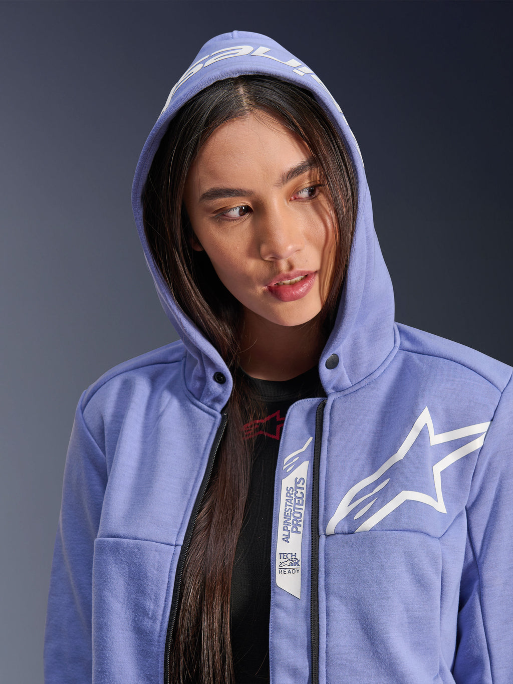 Alpinestars Stella Chrome V2 Sport Hoodie, motorcykelhoodie för dam, blåviolett med vit stjärnlogotyp, med 'Alpinestars Protects' och 'Tech-Air Ready'-märkning längs dragkedjan, avslappnad urban design med huvan uppe
