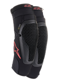 Alpinestars Bionic Flex Knee Protectors, Black and Red, pair of motocross knee guards featuring perforated Nucleon Flex Technology shields, red Astars logos, and elasticated straps on a breathable black mesh sleeve.