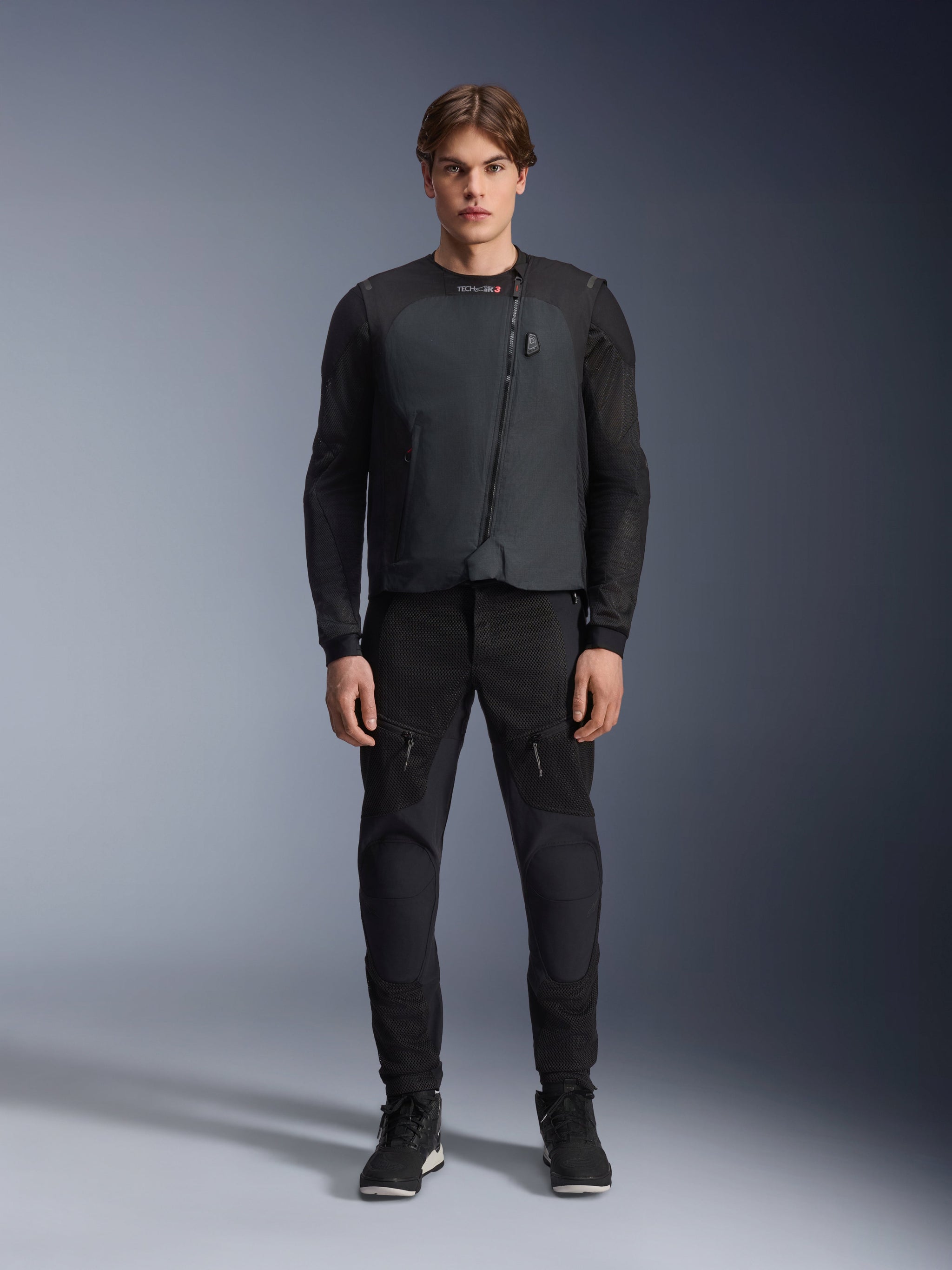 Male model wearing the Alpinestars Tech-Air® 3 V2 System, black autonomous motorcycle airbag vest, front view, paired with black mesh riding pants and black sneakers, showcasing a lightweight and integrated safety outfit for road riding.