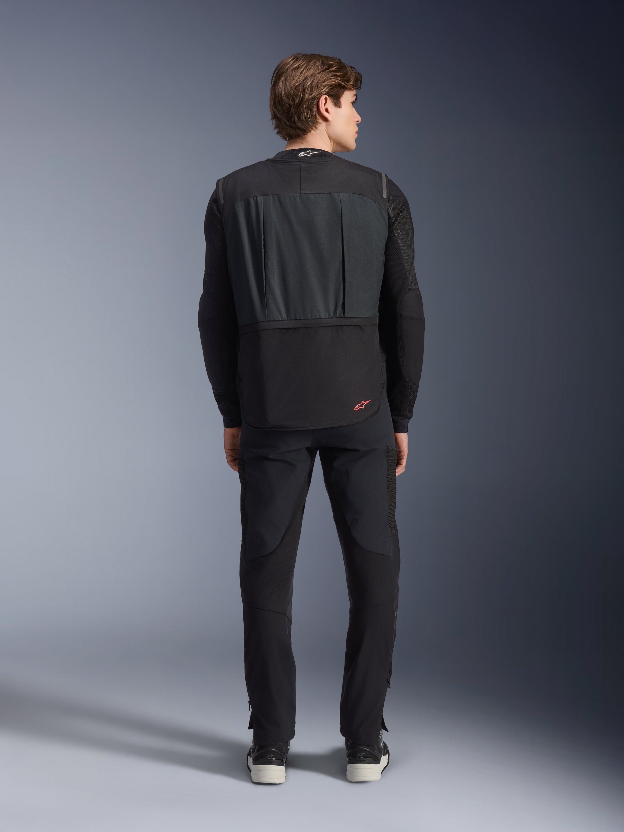 Tech-Air® 3 V2 System, Black, Rear view on male model, autonomous motorcycle airbag vest, worn over a long-sleeved shirt with black pants, featuring a small red Alpinestars logo, slim and lightweight protective gear for road use