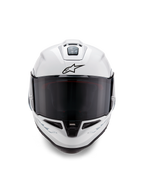 Alpinestars Supertech R10 Solid-hjälm, integralhjälm för racing, blankvit med svarta detaljer, vy framifrån som visar mörkt rökfärgat visir, aerodynamiskt ventilationssystem och svart Astars-logotyp