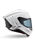 Alpinestars Supertech R10 Solid hjälm, vit glansig och svart matt motorcykelracinghjälm, sidoprofil, aerodynamisk design med bakre vingar och sidoventiler, blåtonat visir, svart Alpinestars-stjärnlogotyp på sidan