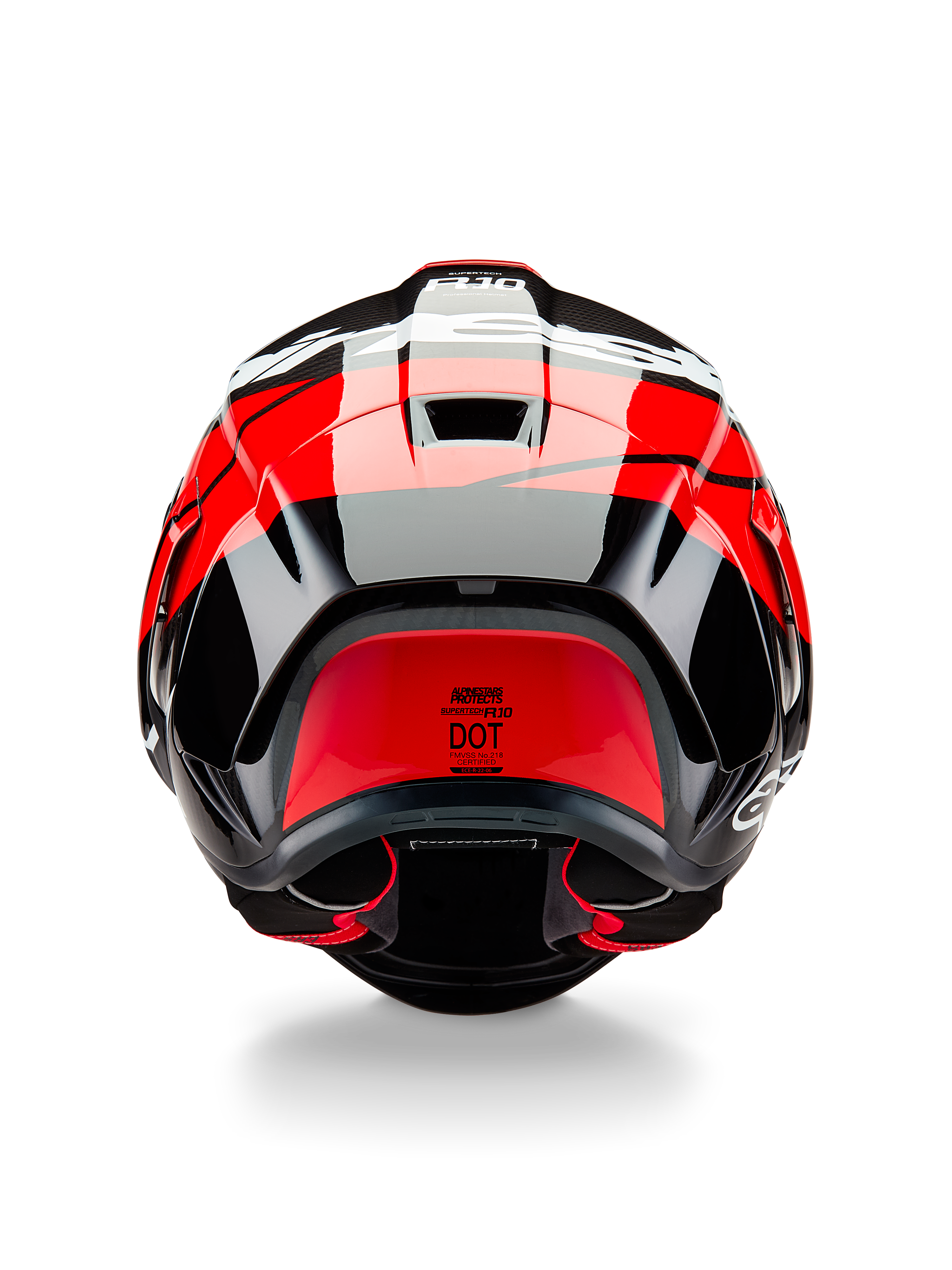 Alpinestars Supertech R10 Element-hjälm, sedd bakifrån, svart kolfiber med högblanka klarröda och vita detaljer, utrustad med aerodynamisk bakspoiler, ventilationsöppningar och DOT-certifieringsetikett, strömlinjeformad racinginspirerad design med kolfiberdetaljer