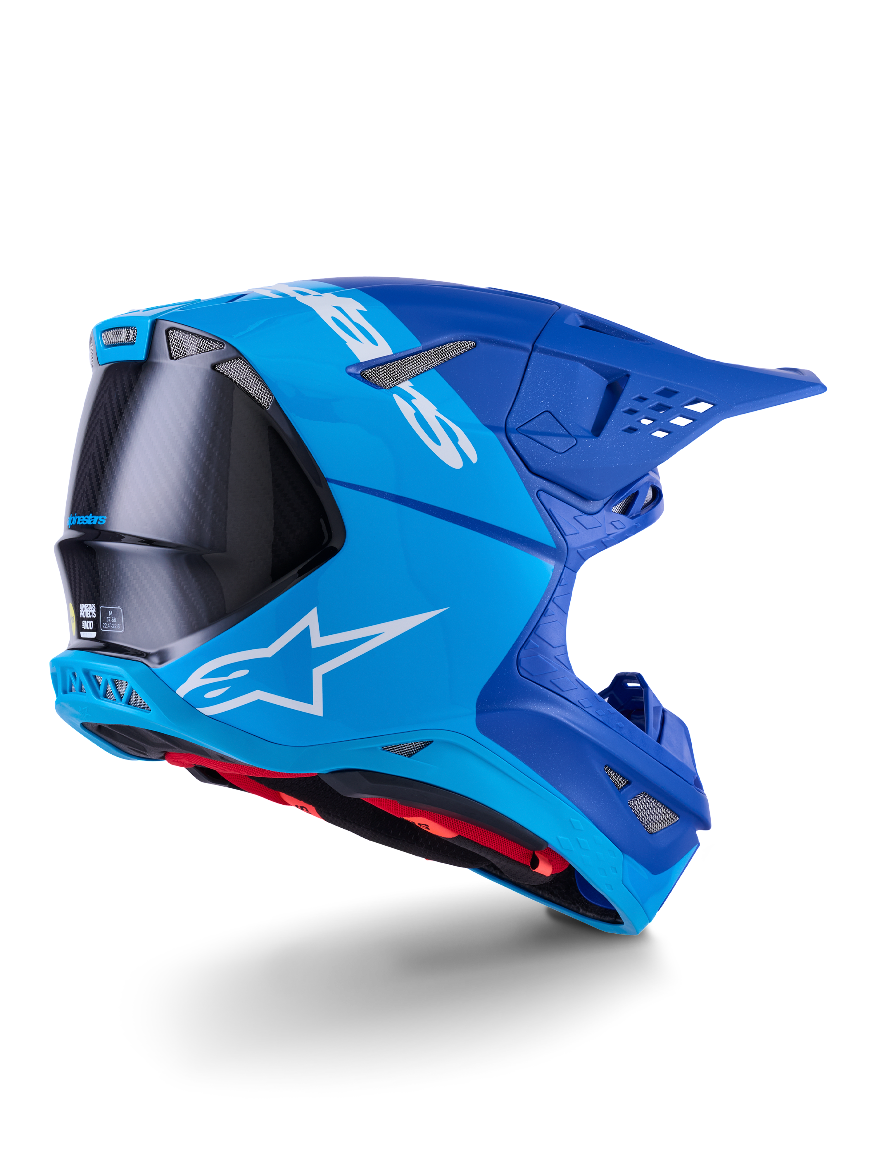 Alpinestars Supertech M10 Flood-hjälm, motocrosshjälm, ljusblå och marinblå med exponerad svart kolfiber, bakre sidoprofil som visar ventilationsöppningar och vit logotyp, rött innerfoder, avancerad aerodynamisk design för terrängprestanda