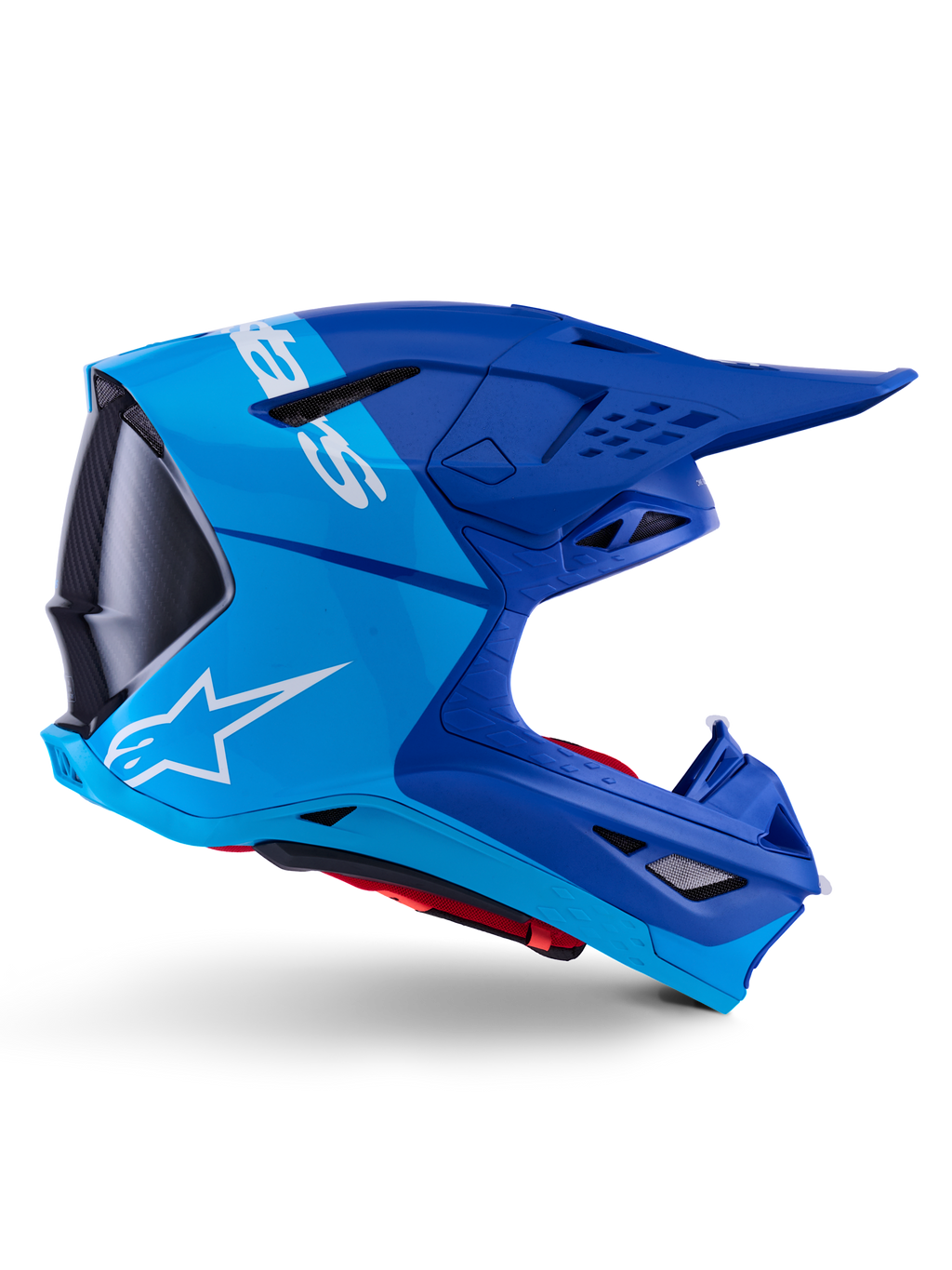 Alpinestars Supertech M10 Flood hjälm, motocrosshjälm, metallicblå och mellanblå med svarta kolfiberdetaljer, sidoprofil, vit logotyp, aerodynamisk design med ventilationsöppningar, kolfibertextur, professionellt skydd för terrängkörning