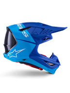 Alpinestars Supertech M10 Flood hjälm, motocrosshjälm, metallicblå och mellanblå med svarta kolfiberdetaljer, sidoprofil, vit logotyp, aerodynamisk design med ventilationsöppningar, kolfibertextur, professionellt skydd för terrängkörning