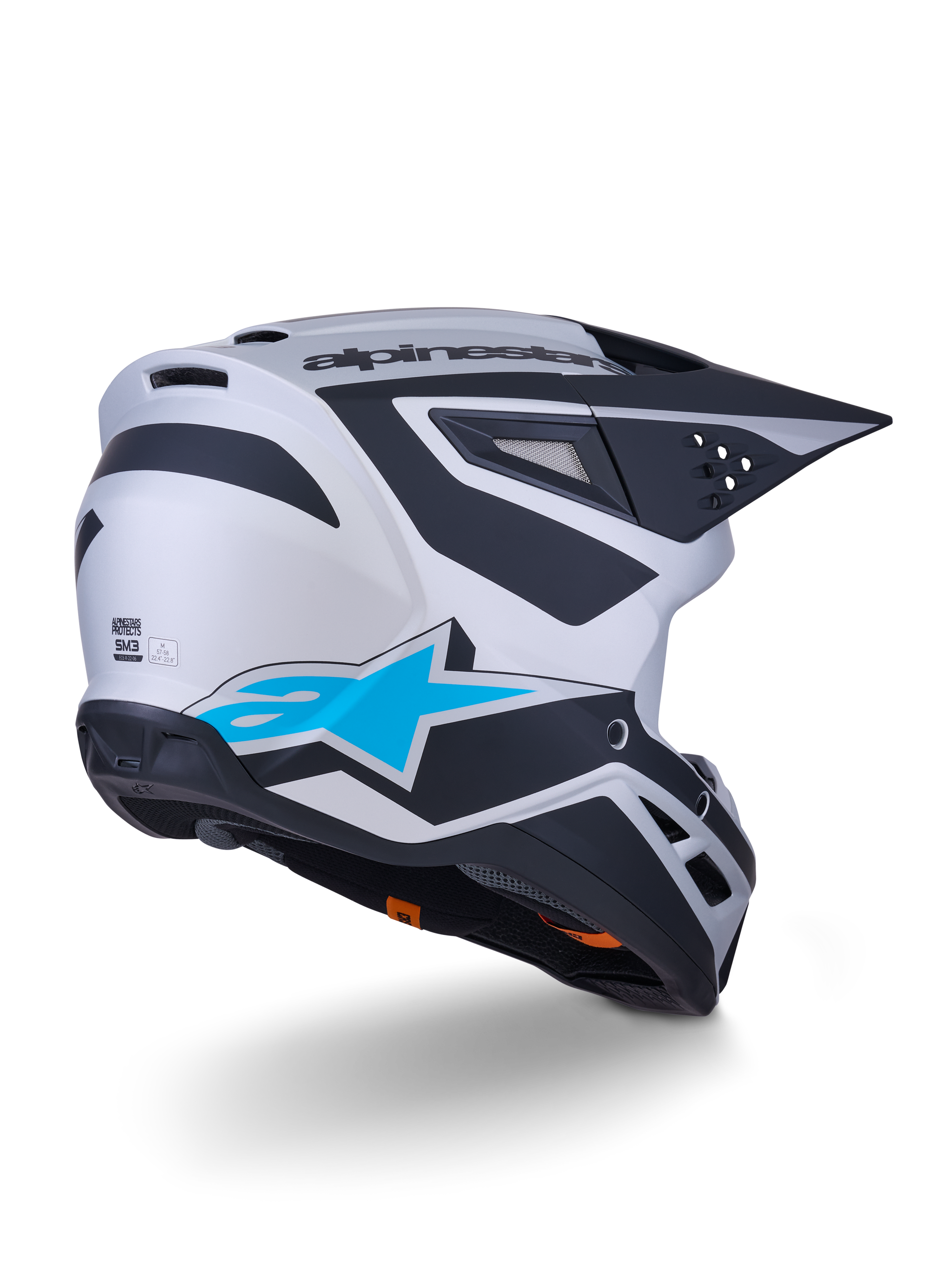 Alpinestars S-M3 Heat-hjälm ECE 22.06, motocrosshjälm, silver, blå och matt svart, vy bakifrån med stor blå stjärnlogotyp och svarta vinklade mönster, aerodynamiskt skal med ventilationsöppningar, högpresterande skydd för terrängkörning