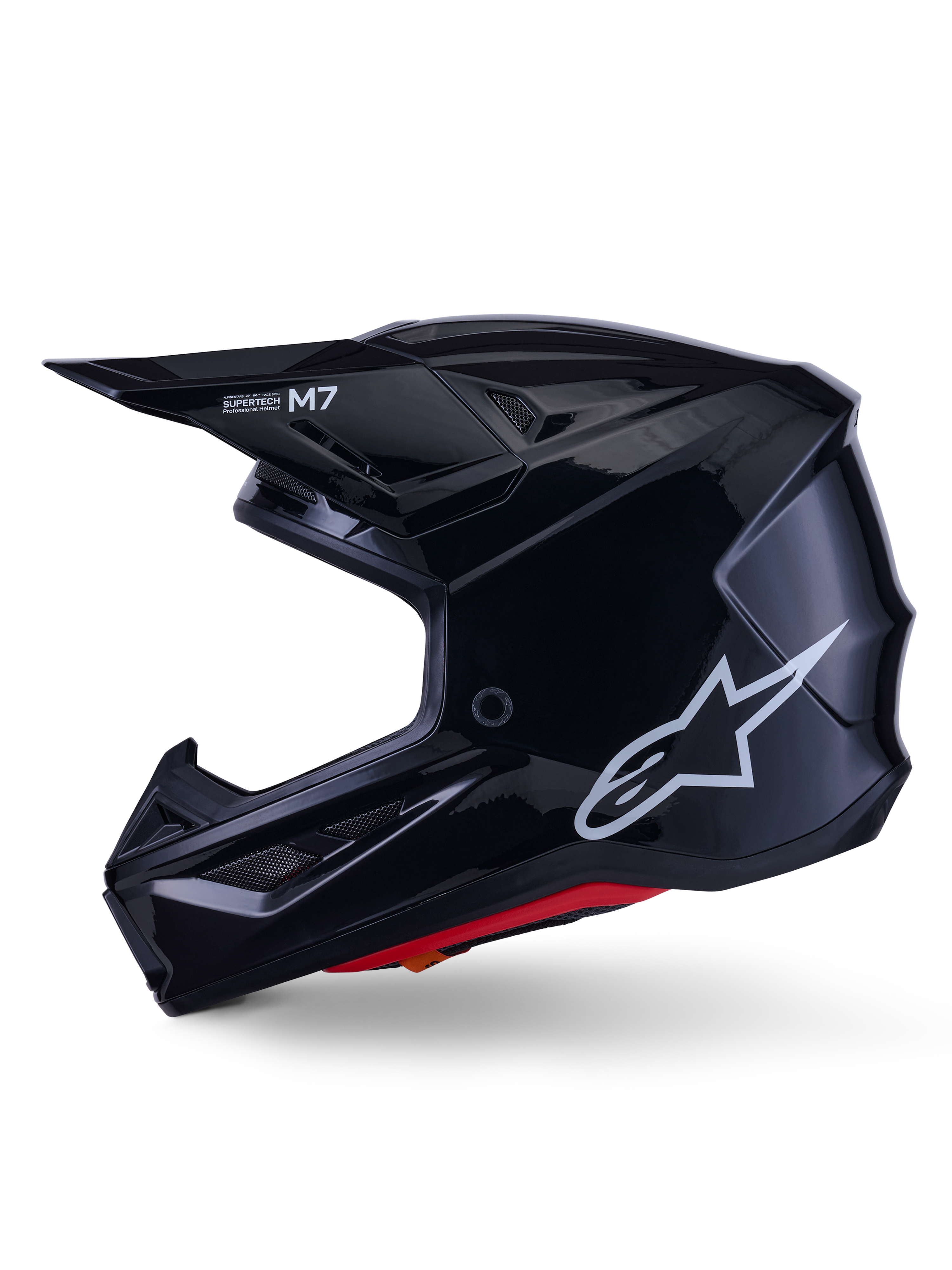 Alpinestars S-M7 Solid hjälm, blanksvart motocrosshjälm, sidoprofil som visar vit Alpinestars-logotyp, aerodynamiskt skal med ventilationsnät och röd invändig vaddering, avancerat skydd för terrängkörning