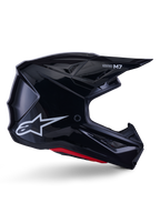 Alpinestars S-M7 Solid-hjälm, motocrosshjälm, blanksvart med vit stjärnlogotyp och röda detaljer, sidoprofil med aerodynamisk design, vinklade nätventiler och Supertech M7-logotyp på visiret.