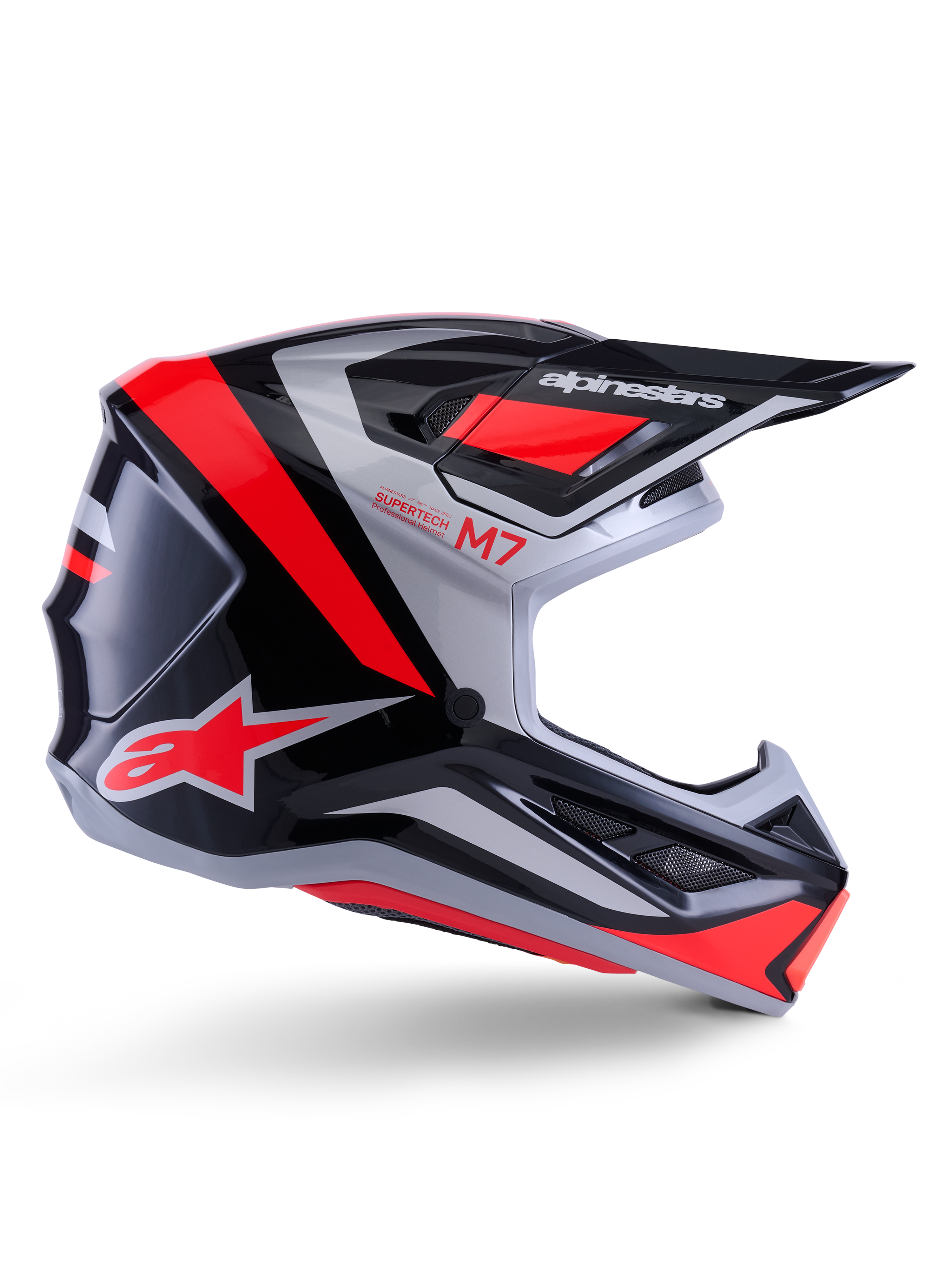 Alpinestars S-M7 Rise-hjälm, motocrosshjälm, svart, silver och röd fluo, sidovy som visar kantig aerodynamisk design med skärm och ventilationsöppningar, glansig finish, Supertech M7-serien
