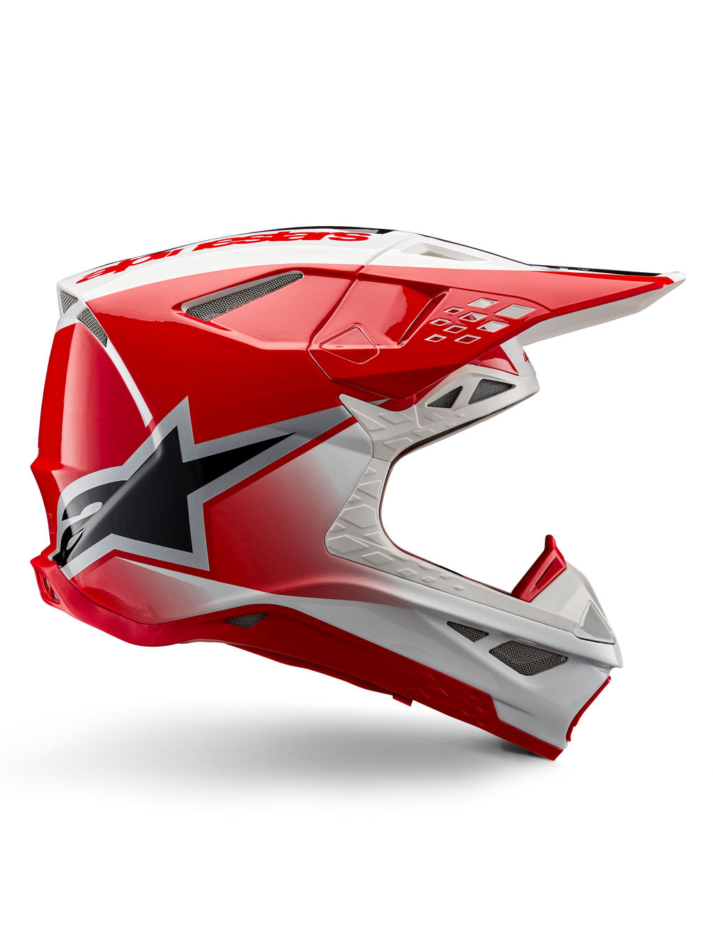 Alpinestars Supertech M10 Unite hjälm, motocrosshjälm, röd och vit högglansig, sidovvy med kantiga geometriska mönster, svart stjärngrafik, flera ventilationsöppningar i nät och aerodynamisk design för terrängkörning