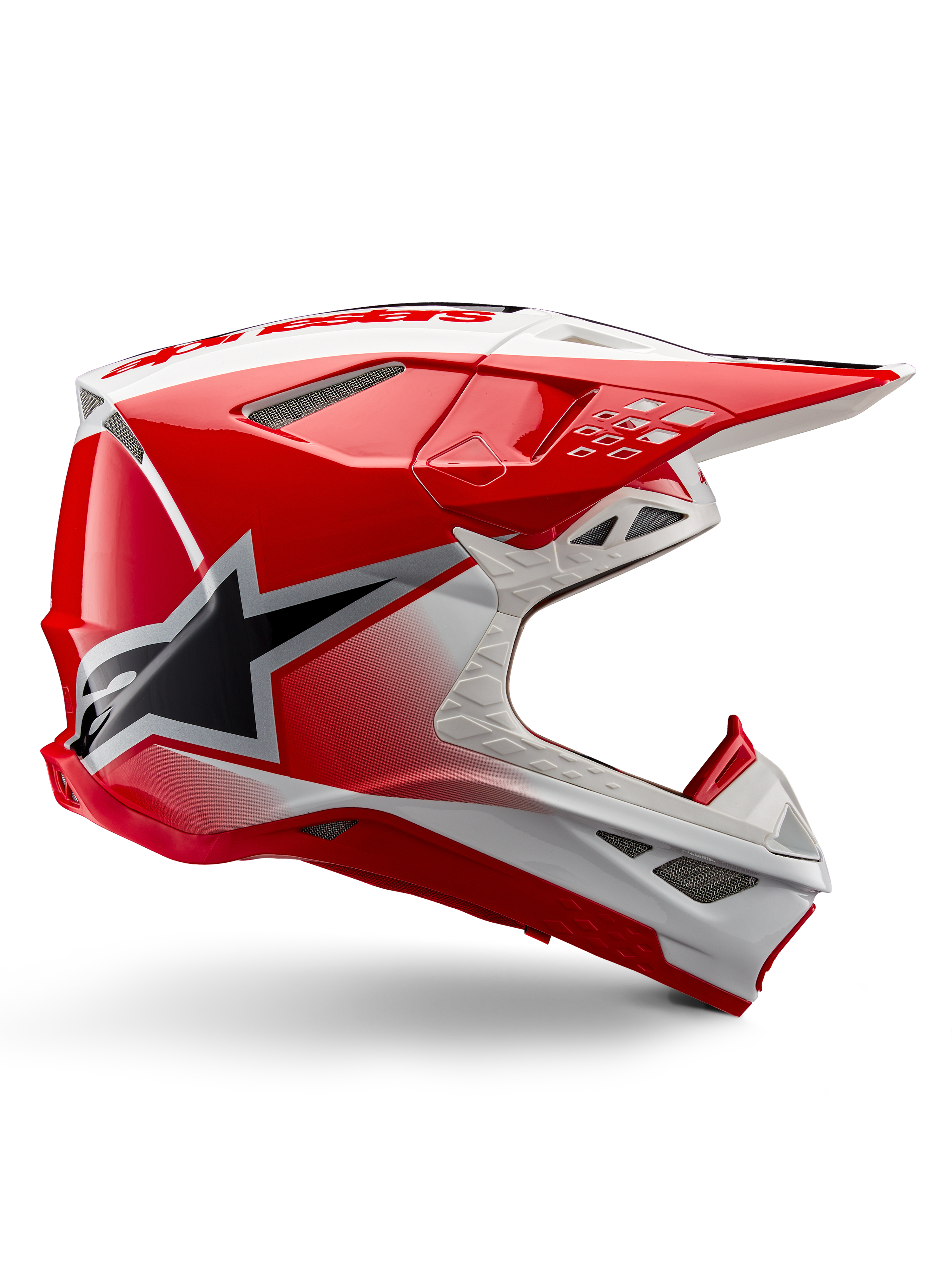 Alpinestars Supertech M10 Unite hjälm, motocrosshjälm, röd och vit högglansig, sidovvy med kantiga geometriska mönster, svart stjärngrafik, flera ventilationsöppningar i nät och aerodynamisk design för terrängkörning