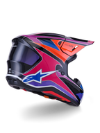 Alpinestars S-M7 Fuse hjälm, motocrosshjälm, glansig finish i blått, lila och rosa med orangea och svarta detaljer, vy snett bakifrån som visar det aerodynamiska skalet, visiret och ventilationsöppningarna, professionellt skydd för off-road-racing