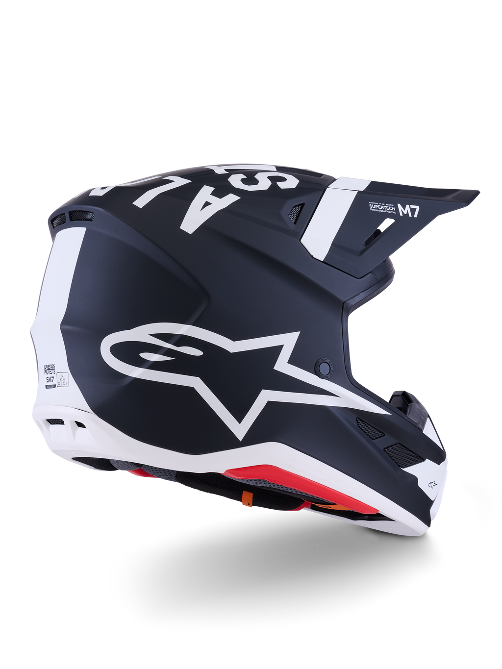 Alpinestars S-M7 Dasher hjälm, motocrosshjälm, matt svart och vit, snett bakifrån med stor vit A-star-logotyp på sidan, tydlig vit branding på toppen, aerodynamisk skaldesign med synliga ventilationsportar och röd vaddering.