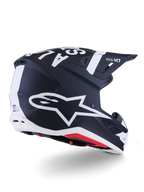 Alpinestars S-M7 Dasher hjälm, motocrosshjälm, matt svart och vit, snett bakifrån med stor vit A-star-logotyp på sidan, tydlig vit branding på toppen, aerodynamisk skaldesign med synliga ventilationsportar och röd vaddering.