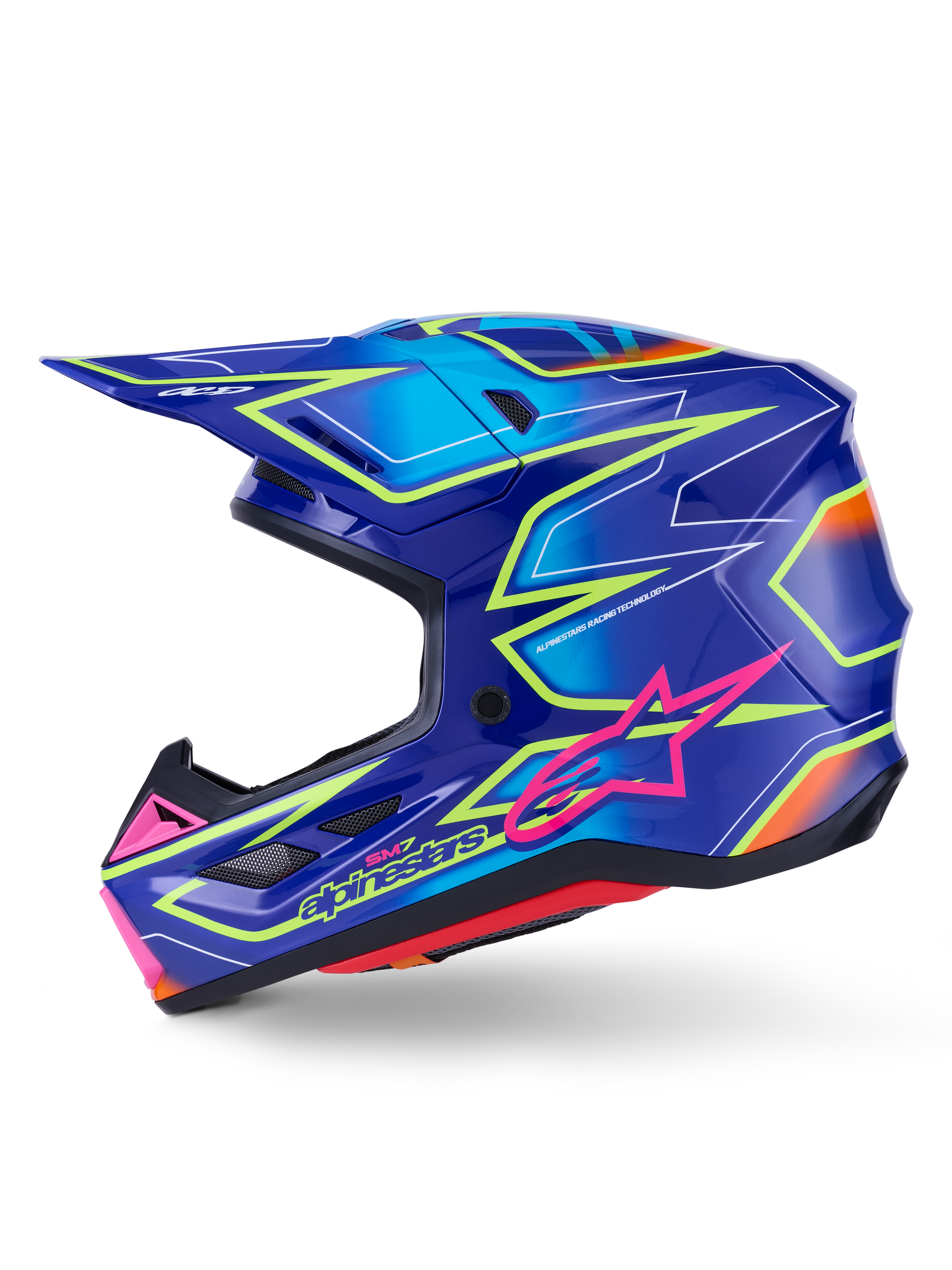 Alpinestars S-M7 Cast hjälm, motocrosshjälm, blå med rosa och neongula glansiga detaljer, profilvy som visar det aerodynamiska kompositskalet, integrerade ventilationsportar, rosa stjärnlogotyp och gul logotyp, konstruerad för skydd vid terrängkörning.