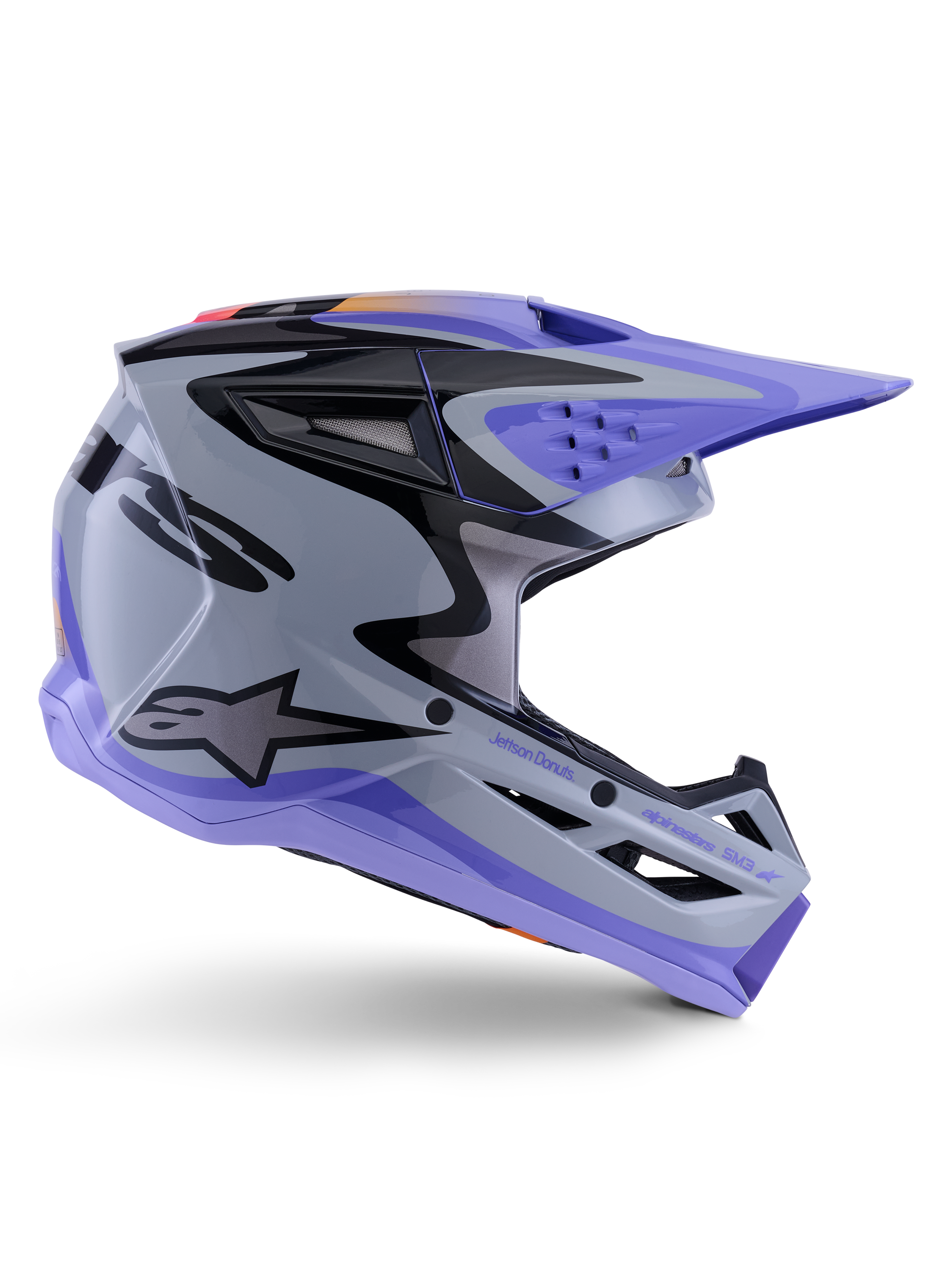 Alpinestars S-M3 Jettson ungdomshjälm, motocrosshjälm, grå, lila och svart blank finish, sidoprofil med skarp vinklad grafik och 'Jettson Donuts'-branding, aerodynamisk skaldesign med ventilationsöppningar och Alpinestars-logotyp, högpresterande skyddsutrustning för ungdomar vid terrängkörning