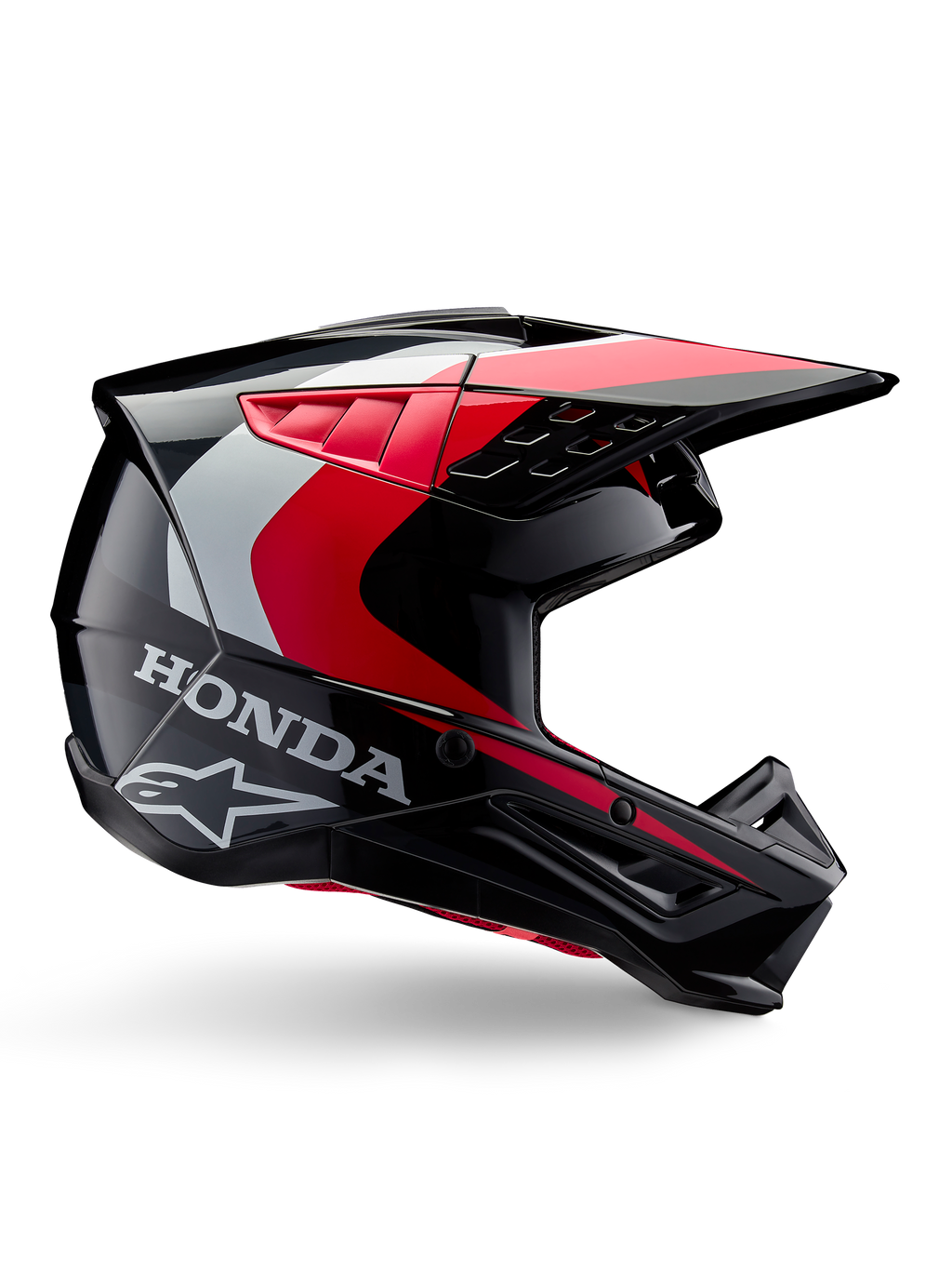 Honda S-M5-hjälm, motocrosshjälm, blank svart och röd med detaljer i vitt och silver, sidovy med logotyper från Honda och Alpinestars, aerodynamisk design med skärm och flera ventilationsöppningar, professionell skyddsutrustning för terrängkörning