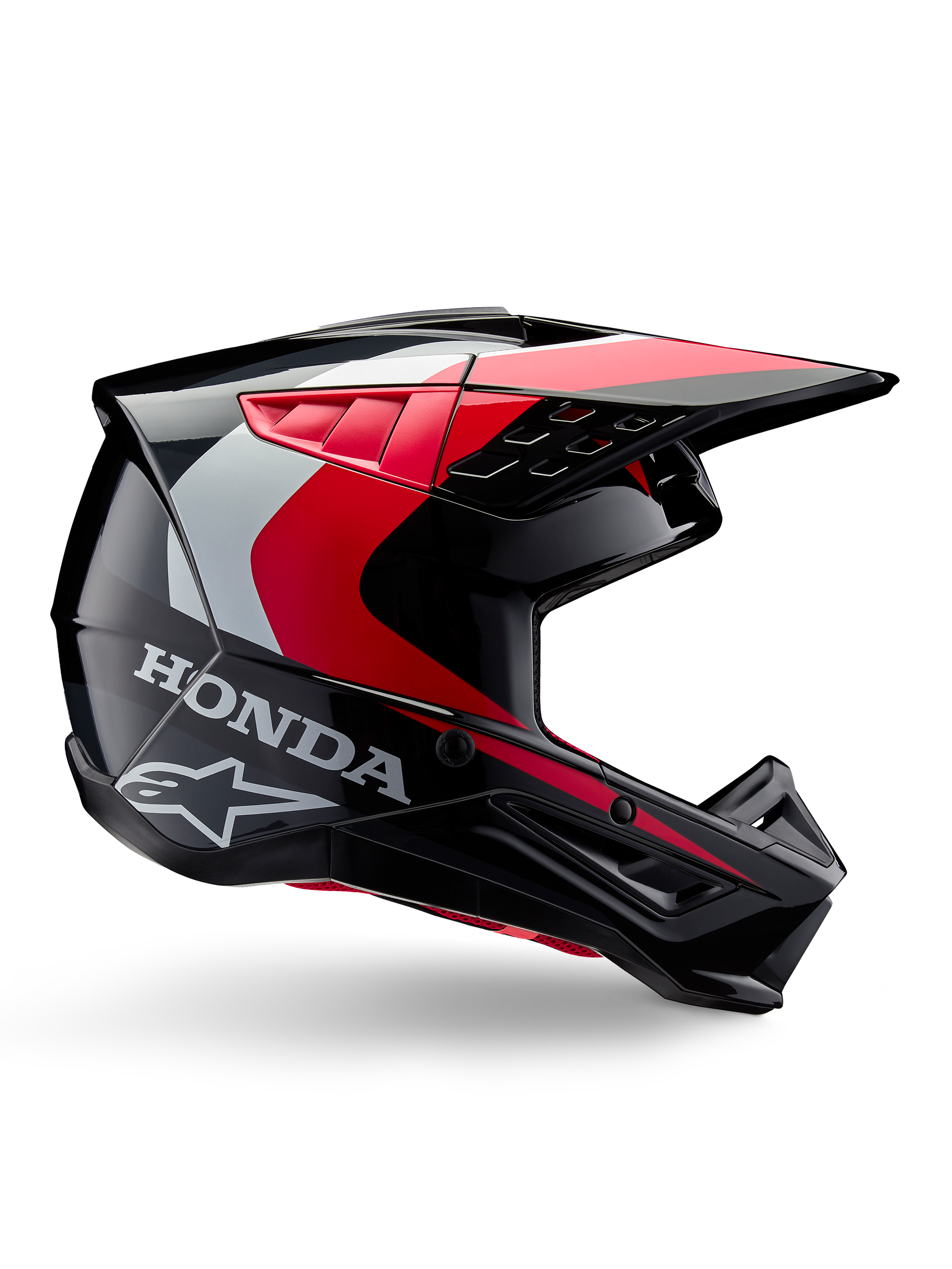 Honda S-M5-hjälm, motocrosshjälm, blank svart och röd med detaljer i vitt och silver, sidovy med logotyper från Honda och Alpinestars, aerodynamisk design med skärm och flera ventilationsöppningar, professionell skyddsutrustning för terrängkörning