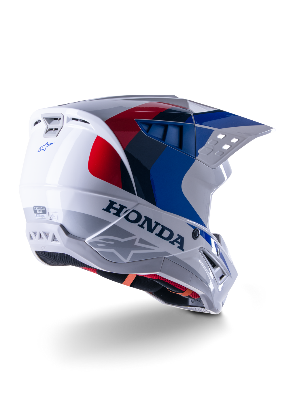 Alpinestars Honda S-M5-hjälm ECE, motocrosshjälm, vit, blå och röd i glansig finish, med tydlig Honda-branding och Alpinestars-logotyper, aerodynamiskt skal med integrerade ventilationsöppningar och justerbart visir, skyddsutrustning för terrängkörning