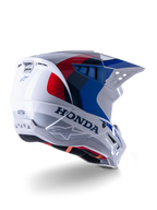 Alpinestars Honda S-M5-hjälm ECE, motocrosshjälm, vit, blå och röd i glansig finish, med tydlig Honda-branding och Alpinestars-logotyper, aerodynamiskt skal med integrerade ventilationsöppningar och justerbart visir, skyddsutrustning för terrängkörning