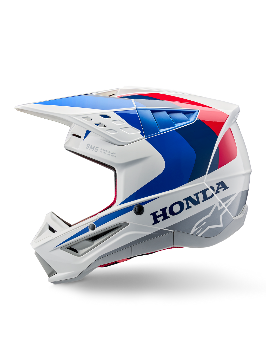 Alpinestars Honda S-M5 ECE-hjälm, vit, blå och röd med blank finish, sidoprofil, med tydlig Honda-logotyp och Alpinestars stjärnlogotyp, aerodynamisk motocrossdesign med flera luftventiler och en framträdande skärm, blank finish