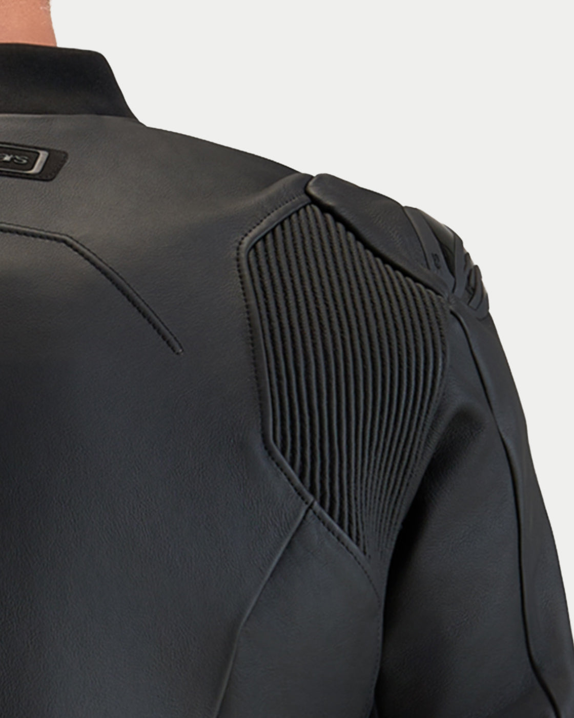 Alpinestars Caliber V2 Leather Jacket, close-up view of the black leather shoulder construction showing ribbed stretch panel details and premium protective design