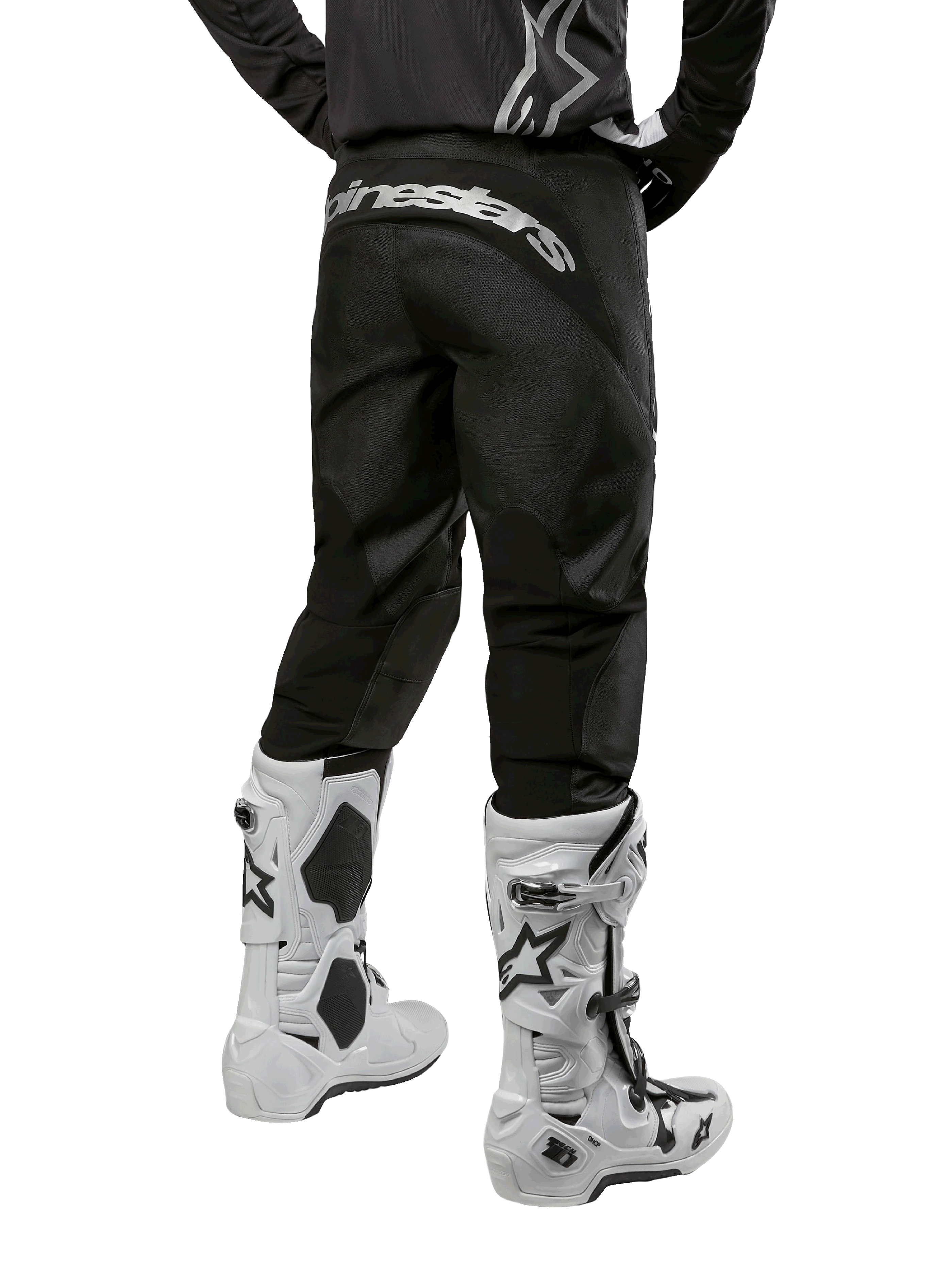 Alpinestars 2024 Fluid Graphite Pants, Motocross Pants, Black and Silver, rear view showing silver Alpinestars branding on the back yoke, worn with white and black motocross boots, durable textile design for off-road riding