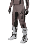 Alpinestars 2024 Fluid Lurv Pants, Motocross Pants, Mud Black and Black, featuring Alpinestars logo, worn with black gloves and white motocross boots, sporty design for off-road racing