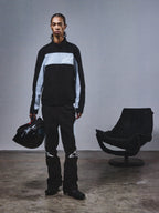 Alpinestars RSRV Track Jacket, svart och grå trackjacka med stjärnlogo, person håller svart hjälm, modern motorsport streetwear, minimalistisk design