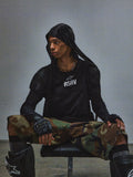 Alpinestars RSRV Nucleon SS Tee, svart t-shirt med vitt RSRV-tryck, person bär svart huvtröja, kamouflagebyxor i grönt och brunt, fingerløsa handskar med knogskydd, svarta knäskydd, urban taktisk stil