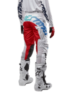 Alpinestars 2024 Racer Hana byxor, motocrossbyxor, vita flerfärgade med röda och blå detaljer, vy bakifrån som visar stor logotyp på baken, bärs med vita och svarta motocross-stövlar, designade för offroad-prestanda och hållbarhet