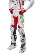 Alpinestars 2024 Racer Hana byxor, motocrossbyxor, vita med röda, blå och limegröna detaljer, skyddande design med knäpaneler i läder, bärs med matchande tröja, röda handskar och vita stövlar med spännen, sportig motorsportoutfit