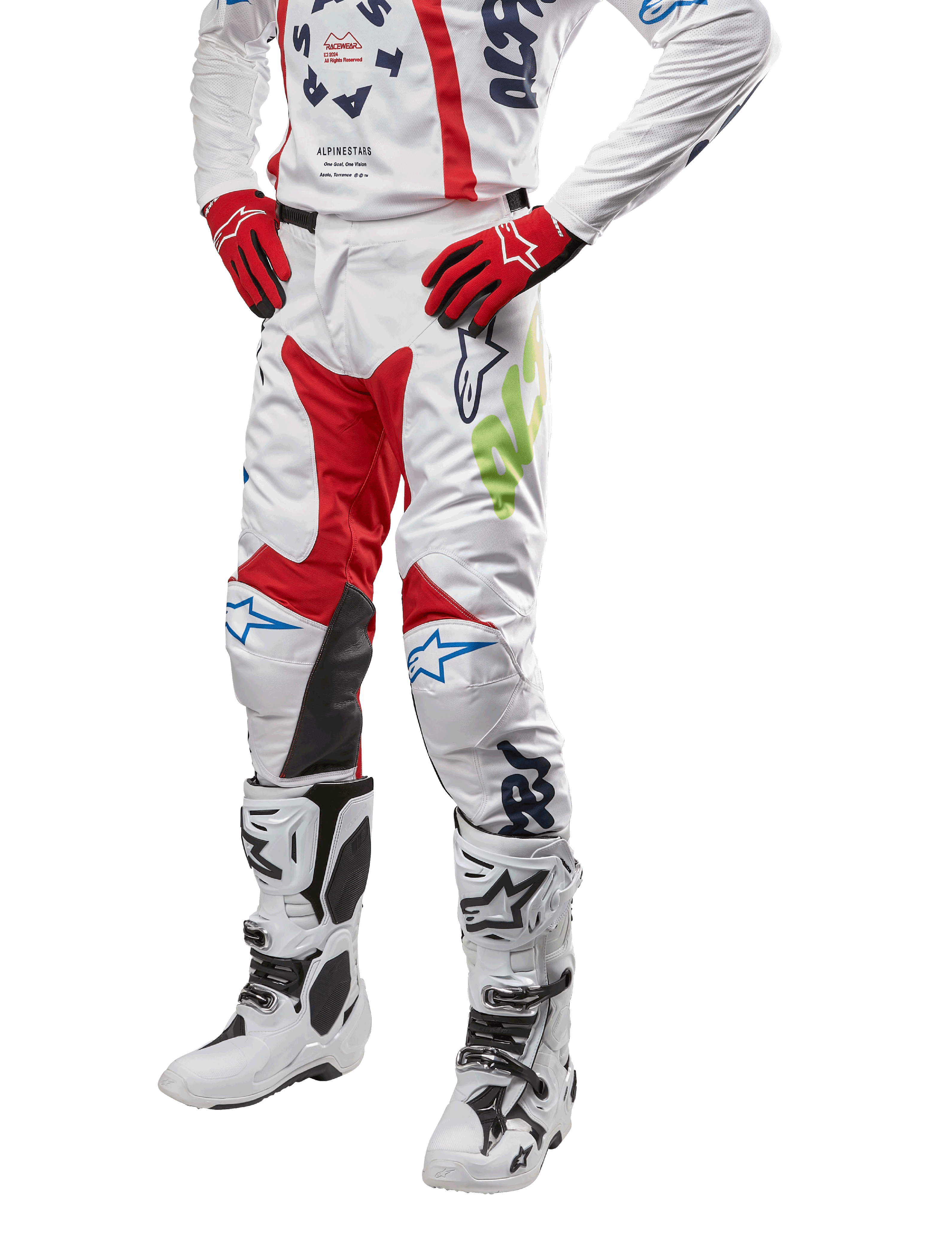 Alpinestars 2024 Racer Hana byxor, motocrossbyxor, vita med röda, blå och limegröna detaljer, skyddande design med knäpaneler i läder, bärs med matchande tröja, röda handskar och vita stövlar med spännen, sportig motorsportoutfit
