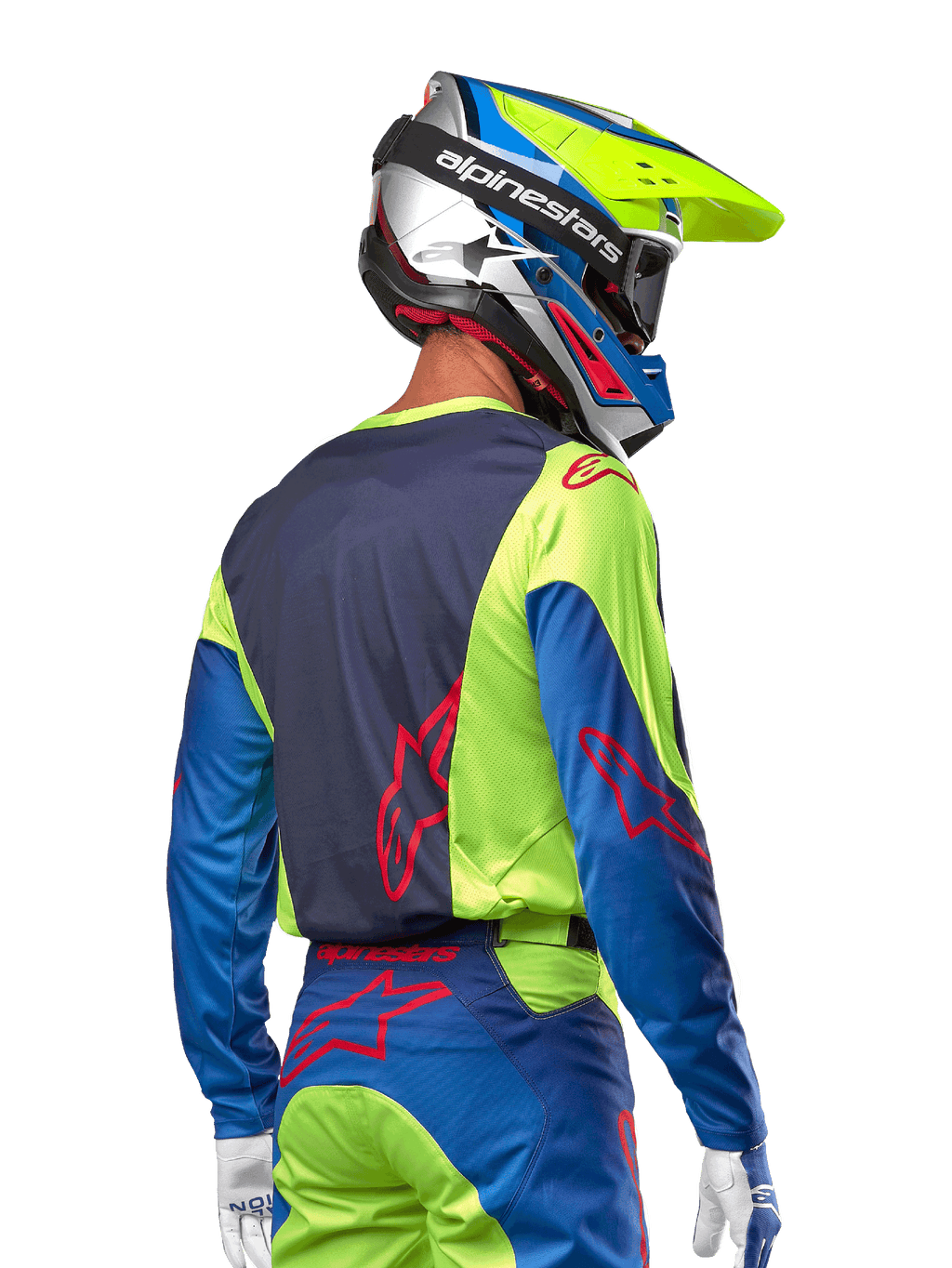 Motocrossförare som bär Alpinestars 2024 Racer Hoen Jersey i Yellow Fluo och Blue Night Navy, med en röd stjärnlogotyp på ryggen, matchande motocrossbyxor och en koordinerad racinghjälm, ryggvy som visar den ergonomiska designen för terrängprestanda.